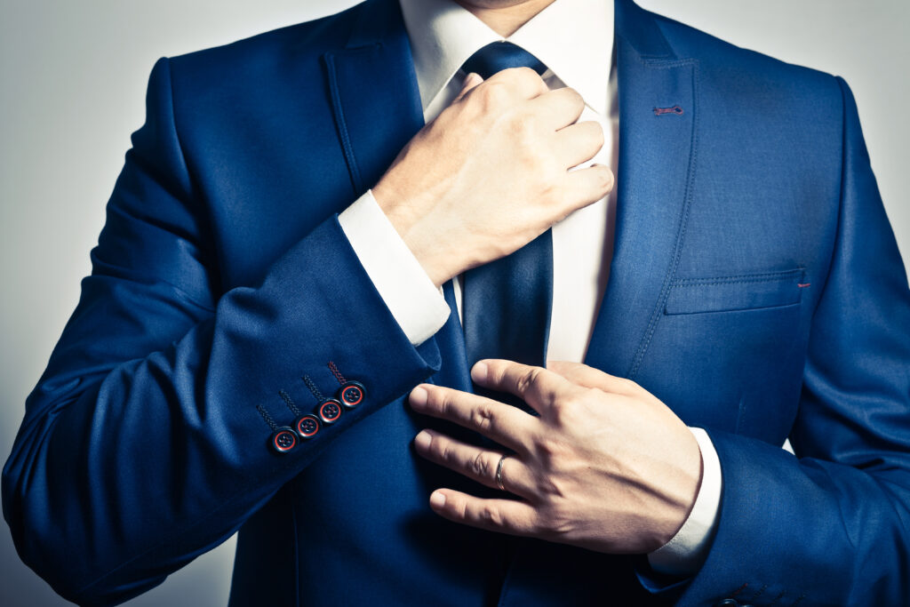 Businessman,In,Blue,Suit,Tying,The,Necktie